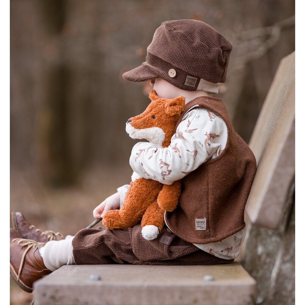child sitting on a bench holding Senger Floppy small rust fox